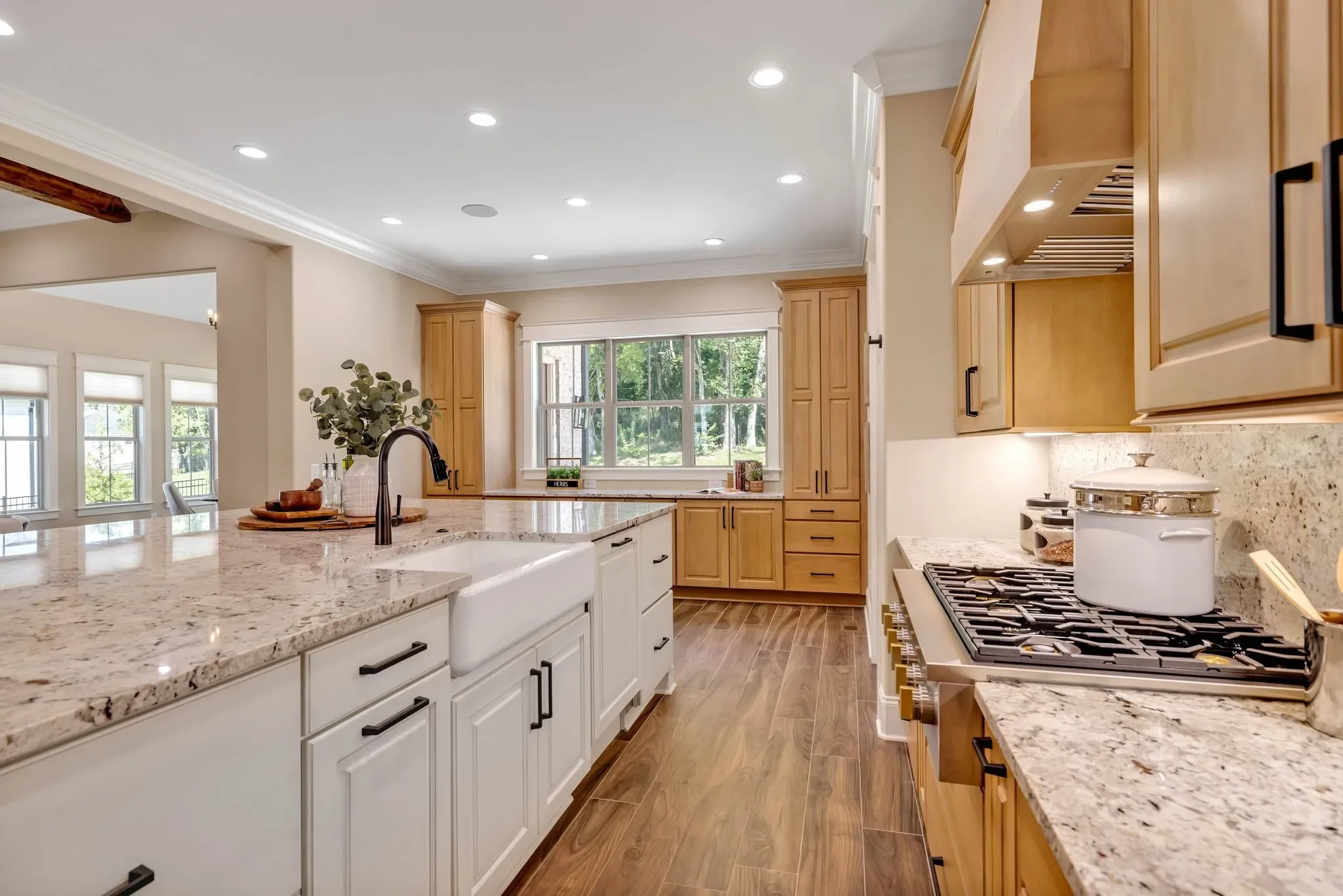 Natural maple kitchen with a white island and a farmhouse apron sink