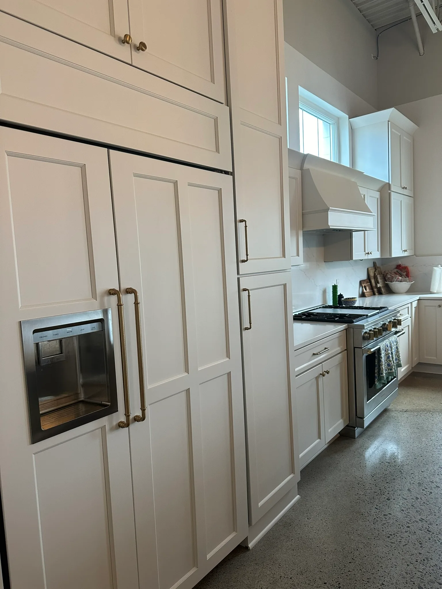 Kitchen with a panel-front refrigerator, painted range hood, and a professional range