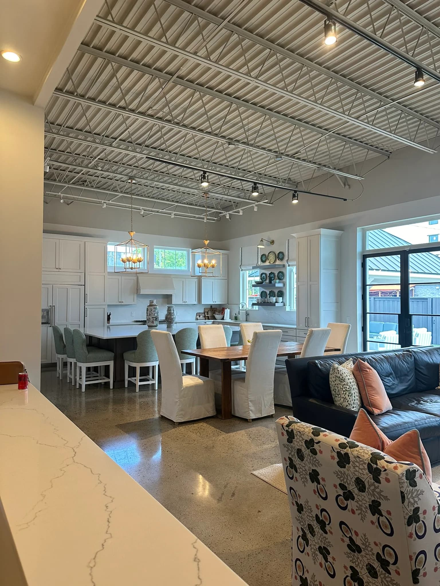 Wide view of the Bella Casa showroom floor with a display kitchen, island seating, and a dining setting